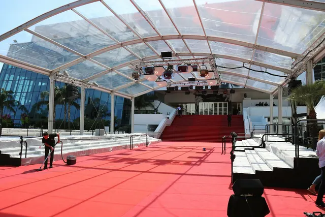 A man riding a skateboard down a red carpet covered walkway The red carpet of the Cannes Film Festival getting ready for a film premiere. Affordable award-show looks explained with examples