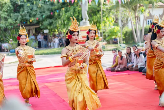 Colorful traditional Cambodian dance performance with women in elegant costumes on red carpet outdoors. Celebrity costumes: common mistakes and better choices