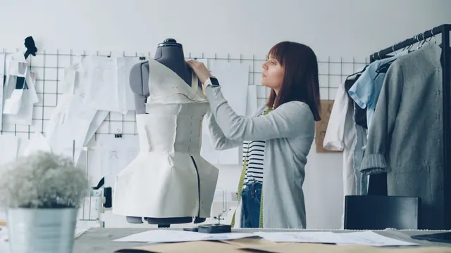 Fashion designer adjusting a dress on a mannequin in a studio filled with sketches. Designers and stylists examples compared: what the good ones share