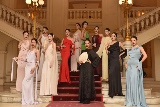 A group of fashion models in elegant gowns posed on a grand staircase indoors. Designers and stylists styles explained with examples