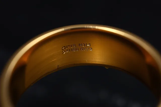 Macro view of stamped hallmark and fineness marks inside a gold ring. Jewelry and watch buying starts with a guide to checking construction