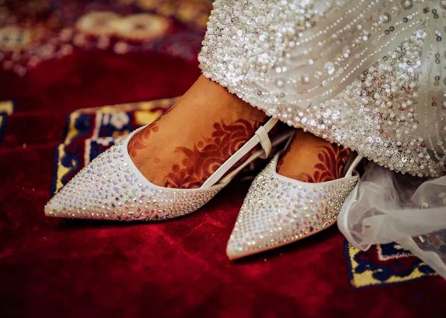 Close-up of bridal shoes adorned with henna design, captured on a traditional red carpet in Kano, Nigeria. Red Carpet Shoe Hacks: How to Last Four Hours in Heels
